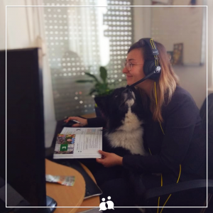 young woman with dog sitting in front of pc doing online nastava